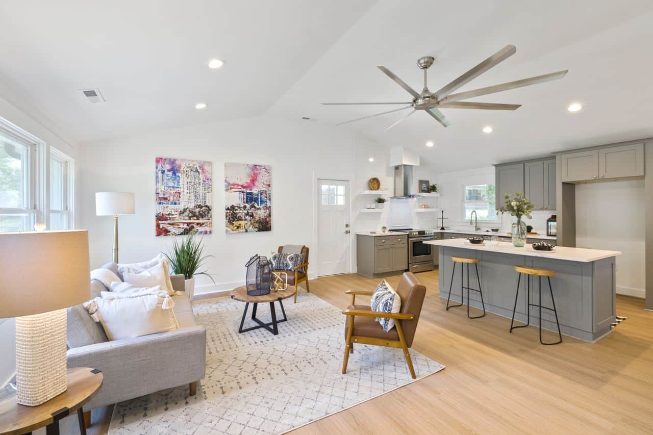Home Spacious open concept living room and kitchen with modern gray cabinetry and ceiling fan.